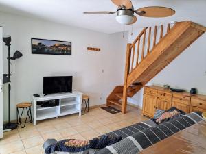 ein Wohnzimmer mit einer Treppe und einem TV in der Unterkunft Belle villa 2 chambres dans résidence sécurisée avec piscine commune 800m de la mer Un vrai Havre de Paix LRCS116 in Portiragnes