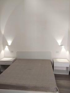 メザーニェにあるPetra Rossa Affittacamereのベッドルーム1室(白いベッド2台、照明2つ付)