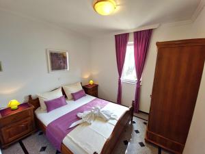 a bedroom with a large bed with purple pillows at Apartment Tomić 3 Makarska in Makarska