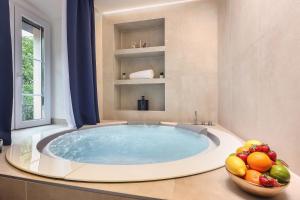 a large tub in a bathroom with a bowl of fruit at Ribica Luxury Rooms in Rijeka