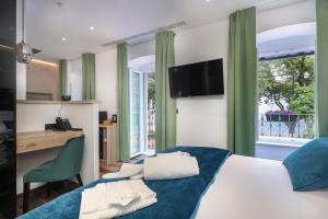 1 dormitorio con cama, escritorio y ventana en Ribica Luxury Rooms en Rijeka