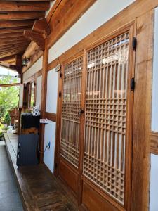 a wooden door with blinds on a house at Beautiful House in Jeonju