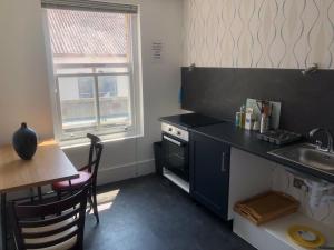 a small kitchen with a sink and a table and a counter at Cosy Studio Apartment - Blackheath, Greenwich in London