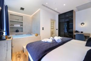 a bedroom with a tub and a bed with towels at Ribica Luxury Rooms in Rijeka