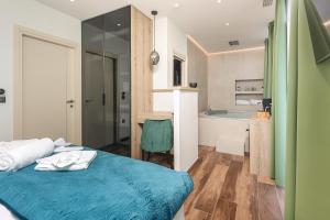 a bedroom with a bed and a bathroom with a tub at Ribica Luxury Rooms in Rijeka