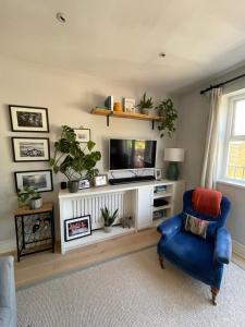un soggiorno con sedia blu e TV di Bright & Stylish 1BD Flat - Wandsworth Town a Londra