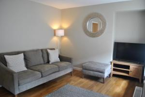 a living room with a couch and a television at Coastal Rest- superb East Neuk townhouse in Anstruther