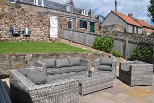 a patio with two wicker couches and a table at Coastal Rest- superb East Neuk townhouse in Anstruther