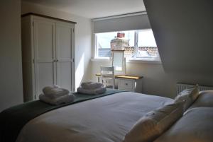 a bedroom with a bed with two towels on it at Coastal Rest- superb East Neuk townhouse in Anstruther