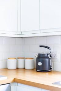 a black tea kettle on a counter in a kitchen at Charming & Central 2BD Flat - Islington in London
