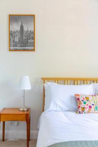 a bedroom with a bed and a table with a lamp at Charming & Central 2BD Flat - Islington in London