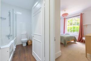 a bathroom with a toilet and a bed and a window at Charming & Central 2BD Flat - Islington in London