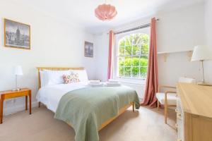 a white bedroom with a bed and a window at Charming & Central 2BD Flat - Islington in London