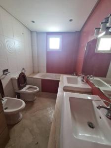 uma casa de banho com 2 lavatórios e um WC em Immense appartement familial haut de l agdal em Rabat