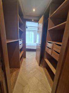 um closet com prateleiras de madeira e um quarto em Immense appartement familial haut de l agdal em Rabat