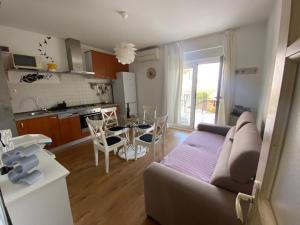 Una sala de estar y una cocina con un sofá y una mesa. en Modern Stylish Apartment near Beach, en Lovran
