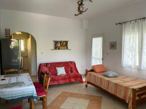 a living room with a red couch and a table at Orange Tree Garden in Pefkochori