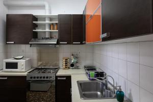 uma pequena cozinha com um lavatório e um micro-ondas em Classy spacious central appartment em Volos