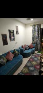 sala de estar con sofás y almohadas azules en الساحل الشمالي. قريه جراند هيلز الكيلو60, en Dawwār ‘Abd Allāh