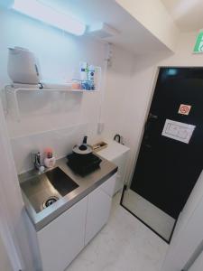 a small kitchen with a sink and a refrigerator at Glen Stage 中浦和 in Saitama