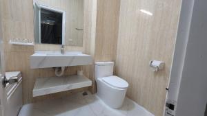 La salle de bains est pourvue de toilettes, d'un lavabo et d'un miroir. dans l'établissement Eureka Resort, Hai Tien Beach, à Thanh Hóa