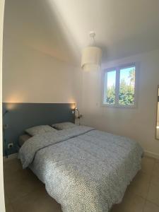 um quarto branco com uma cama e uma janela em Casa di Marina em Santa-Lucia-di-Moriani