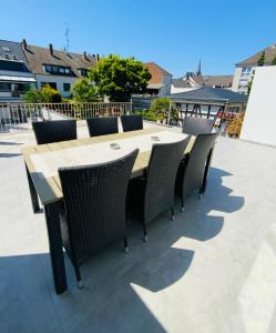 uma mesa de madeira e cadeiras num pátio em Sehr schönes Haus mit Terasse nähe Düsseldorf em Krefeld