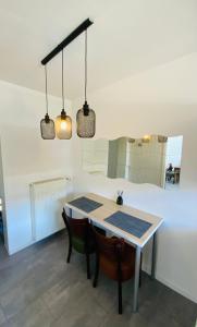 ein Esszimmer mit einem Tisch, Stühlen und 2 Leuchten in der Unterkunft Sehr schönes Haus mit Terasse nähe Düsseldorf in Krefeld