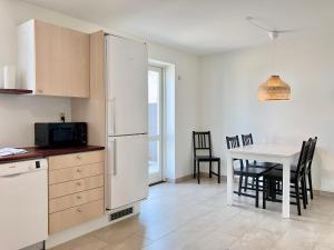 a kitchen with a white refrigerator and a table with chairs at 2 Bedroom Apartment Located At Give in Give