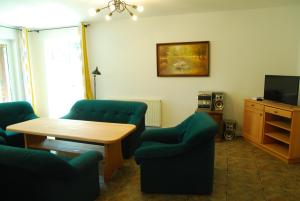 a living room with chairs and a table and a television at Ośrodek wypoczynkowy Jezioro in Studzienice