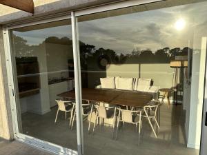 - une table à manger et des chaises sur le balcon d'une maison dans l'établissement Apartamento a estrenar en complejo Mansa inn2, à Punta del Este
