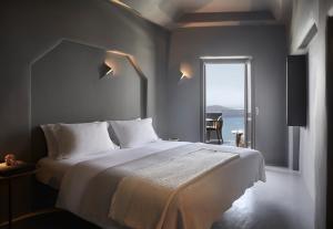 Un pat sau paturi într-o cameră la Kivotos Santorini - Preferred Hotels & Resorts