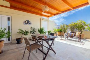 un patio con techo de madera, mesa y sillas en Doma Rooftop Apartment en Heraclión