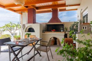 an outdoor patio with a fireplace and a table and chairs at Doma Rooftop Apartment in Heraklio