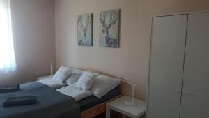 1 dormitorio con sofá y 2 cuadros en la pared en Süni apartman, en Ordacsehi