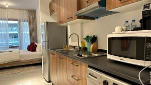 a kitchen with a sink and a microwave at Cozy Studio In Masdar City in Al Qurayyah