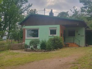 una pequeña casa verde con techo marrón en Gästehaus Anita, en Britten