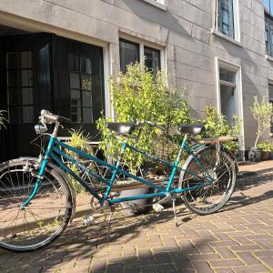 Una bicicleta azul estacionada frente a un edificio en Villa Conti, en Dordrecht
