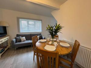 a dining room table with chairs and a couch at Ground floor flat with parking, sleeps 3 in Wheatley