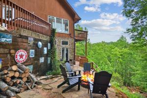 eine Terrasse mit Stühlen und einer Feuerstelle vor einem Haus in der Unterkunft Lily's Lookout Lodge - Helen, GA in Helen