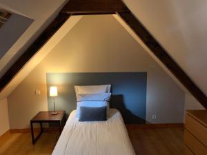 a attic bedroom with a bed and a table at Domaine des Trois Rivières in Merlevenez +51 photos