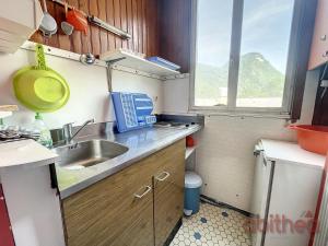 una pequeña cocina con fregadero y ventana en Appartement 15, 4 couchages, en Aulus-les-Bains