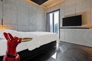 a white bedroom with a large bed and a tv at Ingu Stay in Yangyang
