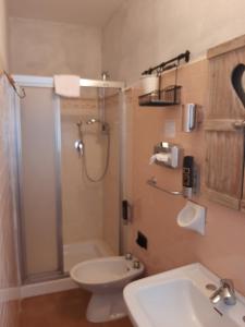 a bathroom with a shower and a toilet and a sink at Hotel Calvanella in Sestola
