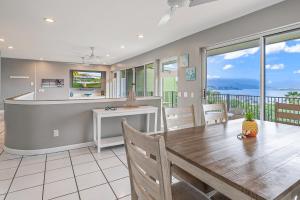 a dining room with a table and a view of the ocean at Ka Hale me Ka ike 30 Night Minimum in Kaneohe