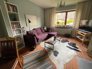 ein Wohnzimmer mit einem lila Sofa und einem Tisch in der Unterkunft Ferienhaus Jenny in Flensburg