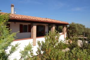 une maison blanche avec un toit rouge dans l'établissement Mi casa es tu casa 79, à Portoscuso
