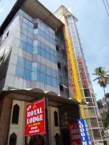 un edificio con cartelli di fronte di NEW ROYAL LODGE a Mangalore