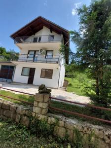 a white house with a fence in front of it at Apartman Emanuel in Jajce