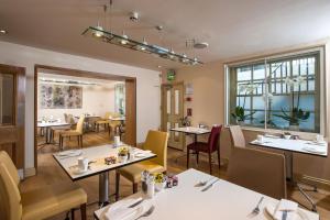 um restaurante com mesas e cadeiras e uma sala de jantar em Sydney House Chelsea em Londres